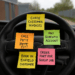 Sticky notes on a UK van steering wheel with reminders for admin tasks like chasing invoices and booking jobs.